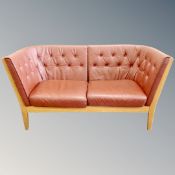 A Danish oak framed settee in brown buttoned leather