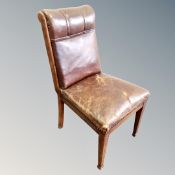 An antique oak dining chair in brown leather