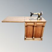 A vintage Jones sewing machine in mahogany cabinet