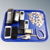 A tray of foreign coins, vintage and later mobile phones, iphones, brass lighter,