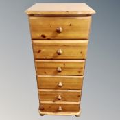 A narrow pine six drawer chest