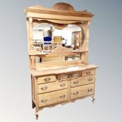 An Edwardian carved oak mirror backed sideboard fitted with seven drawers