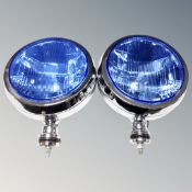 A pair of circular headlamps with blue glass lenses