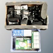A box and basket containing assorted digital cameras, binoculars,