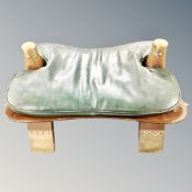 A camel stool with leather saddle