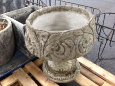 A pair of concrete planters on pedestals
