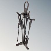 A four piece cast iron fire companion set on stand