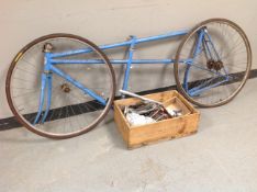 An FFCT tandem bike frame with wheels and box containing parts