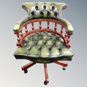 A swivel captain's armchair in green buttoned leather
