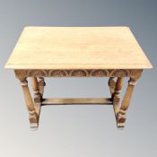 A carved oak occasional table with under stretcher