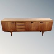 A teak Greaves & Thomas three door sideboard on raised legs