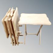 A set of four folding occasional tables on stand