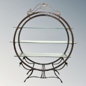 A contemporary circular metal three tier shelving unit on legs