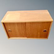 A mid century teak double sliding door wall cabinet