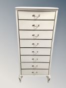 A cream and gilt narrow eight drawer chest