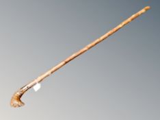 An antique folk art stout walking stick carved with a head of The Green Man handle