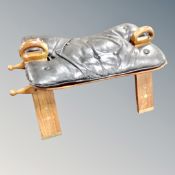 A brass inlaid camel stool with leather buttoned saddle