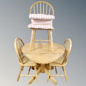 A contemporary rubber wood drop leaf kitchen table together with three chairs