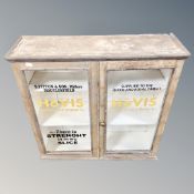 An antique pine double door wall cabinet with later hand painted advertisement 'Hovis bread and