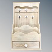 A contemporary pine key cabinet fitted with magazine rack and drawer