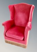 A wing backed armchair in tasseled fabric