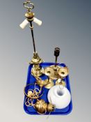 A tray containing three brass converted lamps and a pair of candlesticks.