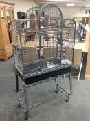 A metal bird cage on stand, 86cm wide by 54cm deep by 168cm high.
