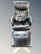 A Scandinavian black leather armchair with matching footstool