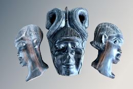 An African carved wooden mask wall plaque and two further similar,