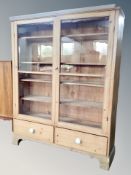 A glazed pine bookcase width 134 cm