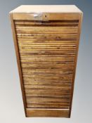 A beech office shutter fronted cabinet with key,