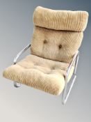 A Scandinavian chrome framed easy chair in olive buttoned fabric