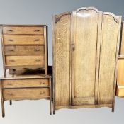 A 1930's oak three piece bedroom suite comprising of dome topped wardrobe,