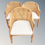 A set of three wicker tub armchairs