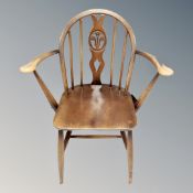An Ercol elm and beech Fleur de Lys open armchair