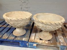 A pair of concrete garden planters on stand