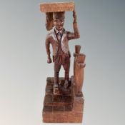 A tall carved wood figure of a baker with tray of pies descending steps,