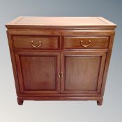 A contemporary Chinese cherry wood double door sideboard, 91cm wide by 48cm deep by 87cm high.