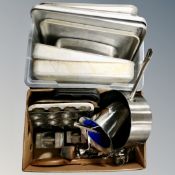 Two boxes of kitchen pans and trays, cast iron weights, kitchen utensils.