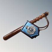 A turned wooden police truncheon and a Newcastle Upon Tyne Constabulary badge mounted on easel