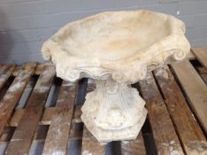 A concrete classical garden bird bath on pedestal