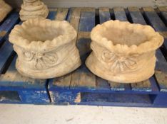 A pair of concrete garden sack planters