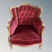 A baroque style carved beech framed armchair in red buttoned dralon
