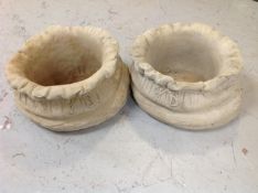 A pair of concrete garden sack planters