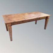 A contemporary stained pine kitchen table and six rail back chairs