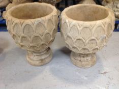 A pair of concrete garden pineapple planters on stands