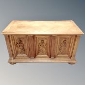 A continental oak carved panel coffer on bun feet