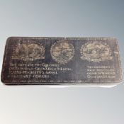 An antique tin chocolate box containing miliary buttons