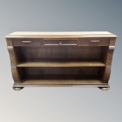 An oak open bookcase fitted with three drawers,