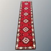 An eastern woollen runner on red ground,